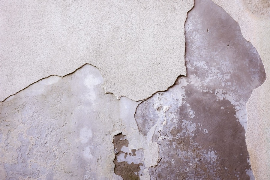 A close-up view of a section of drywall with visibly bubbled joint tape, indicating damage.