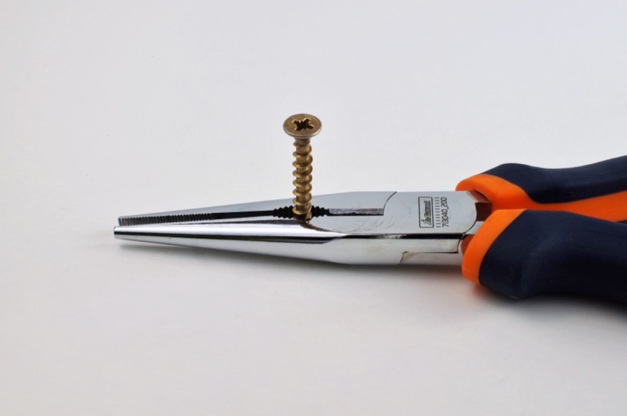 Drywall screw gun driving a screw into drywall, creating a slightly recessed head.